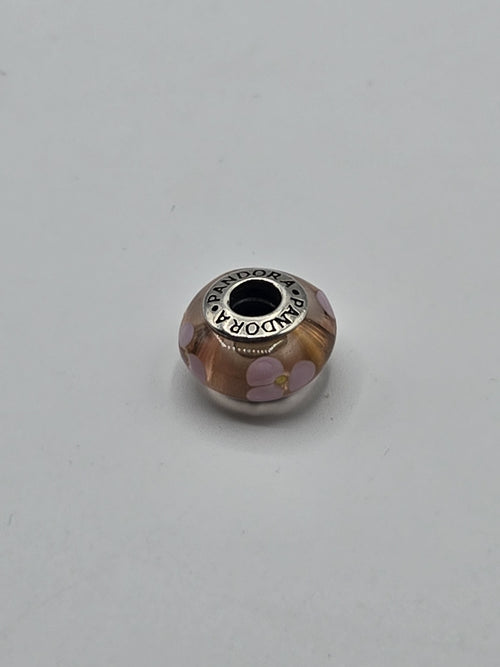 Pandora Amber and Lilac Flower Murano Glass Charm on a plain light background