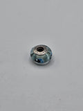 Pandora Aqua and Navy Dot Murano Glass Charm on a plain light background