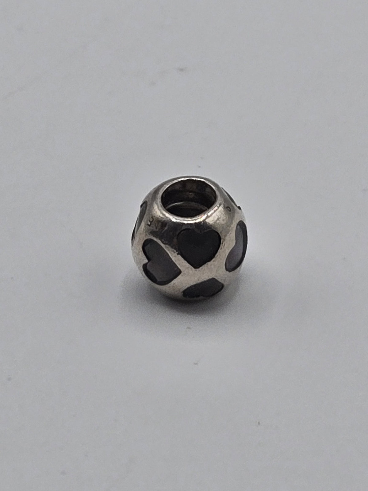 Pandora Black Enamel Hearts Charm on a plain light background