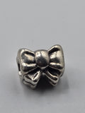 Pandora Bow Charm on a plain light background
