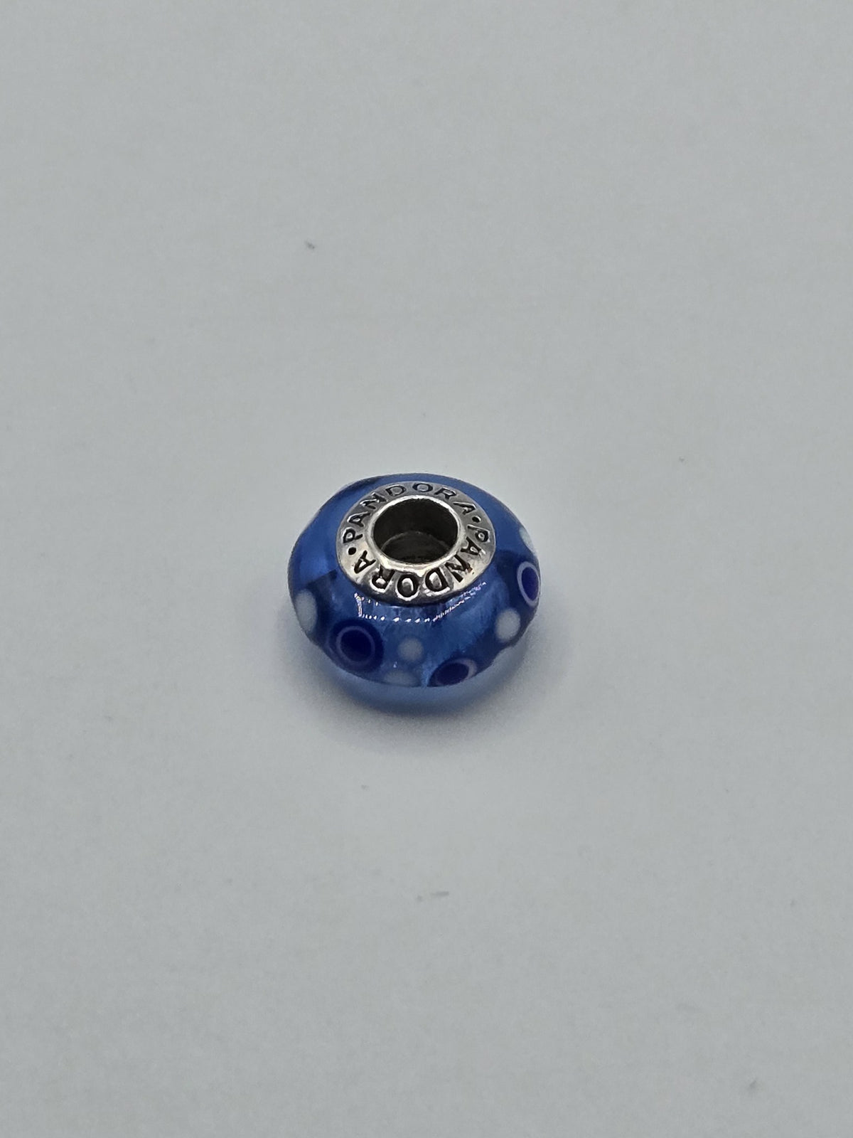 Pandora Cobalt Blue Millefiori Dot Murano Glass Charm on a plain light background