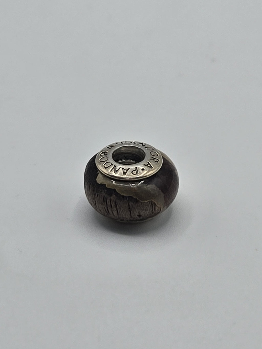 Pandora Dark Brown Textured Wood-Look Charm on a plain light background