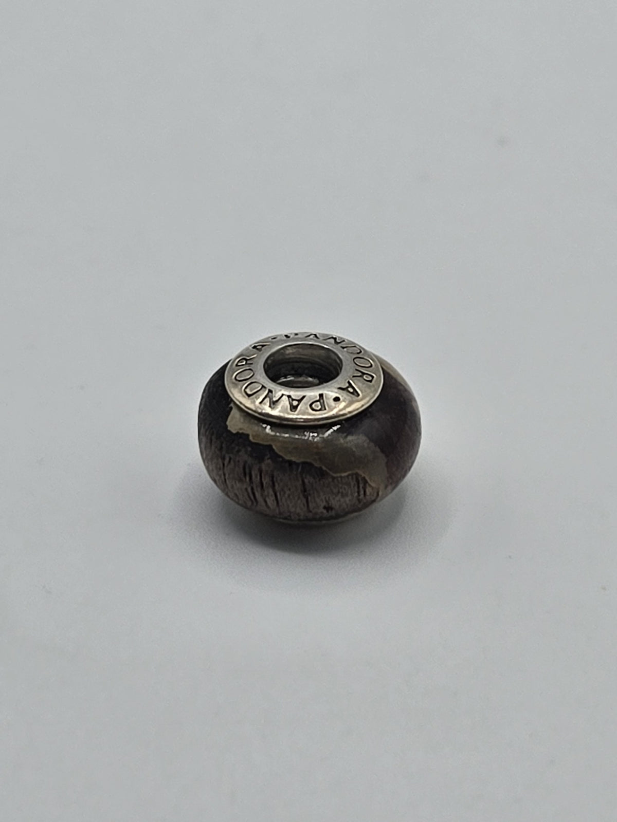 Pandora Dark Brown Textured Wood-Look Charm on a plain light background