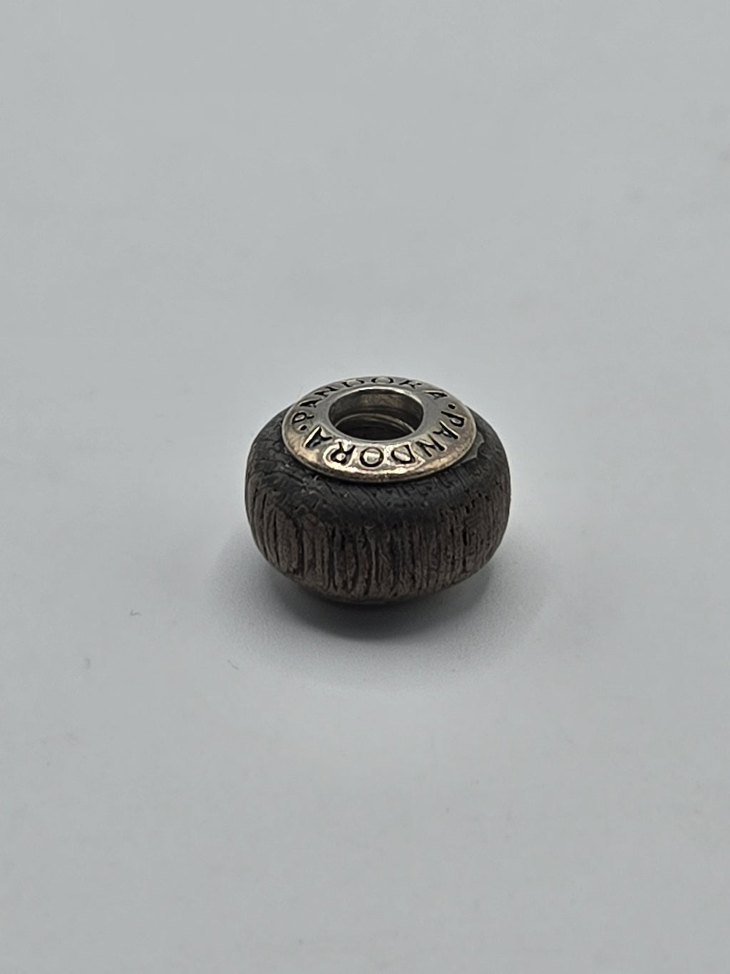 Pandora Dark Brown Textured Wood-Look Charm on a plain light background