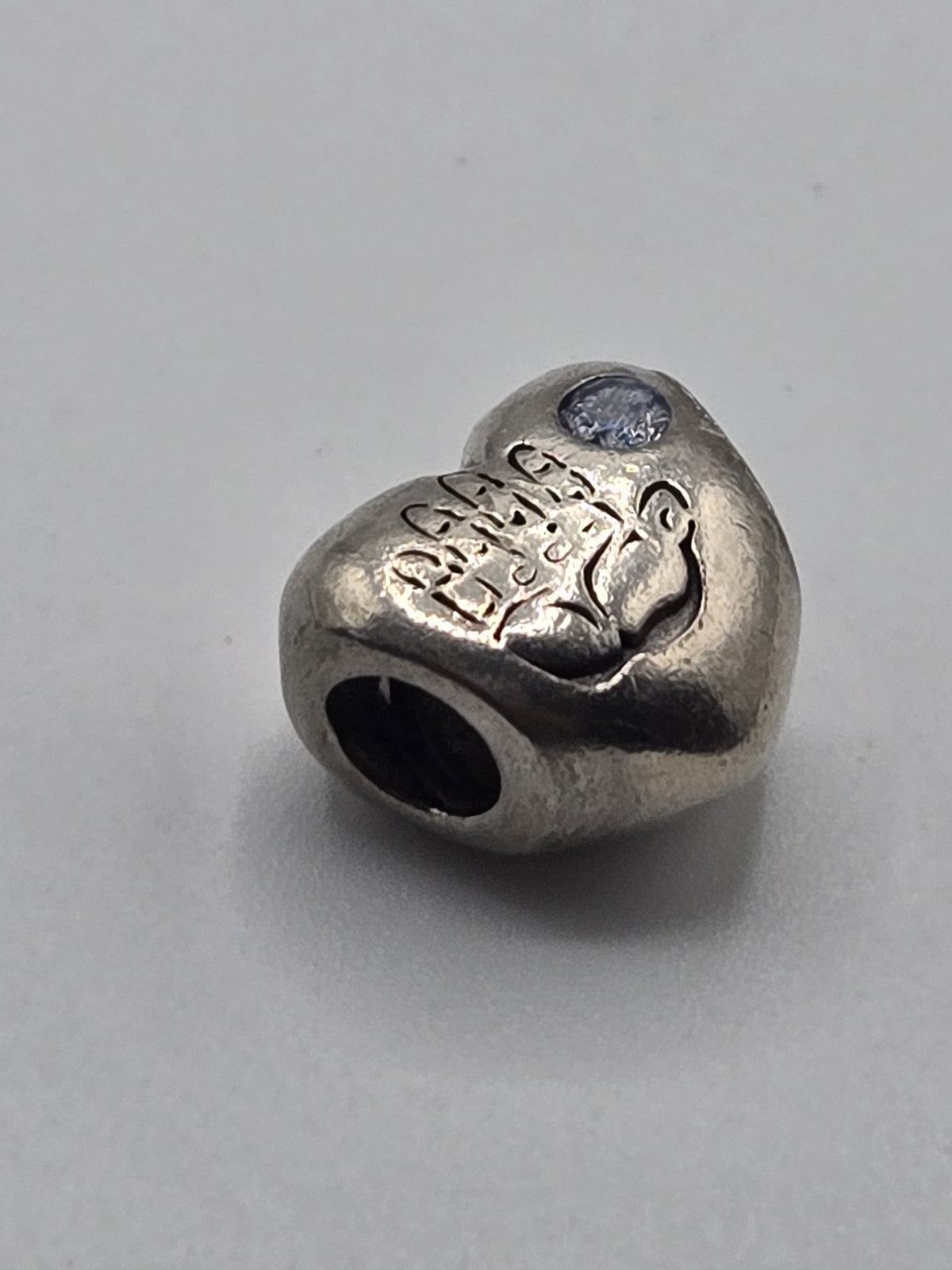 Pandora Engraved Heart Charm with Rose and Blue Stone on a plain light background