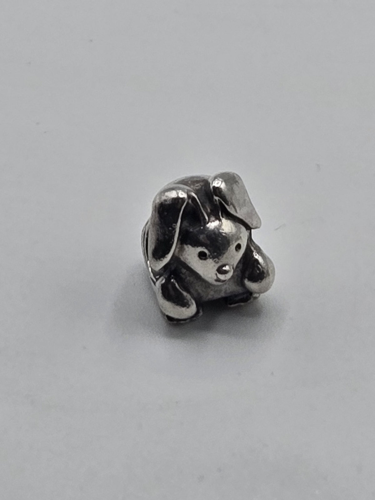 Pandora Floppy Eared Puppy Charm on a plain light background