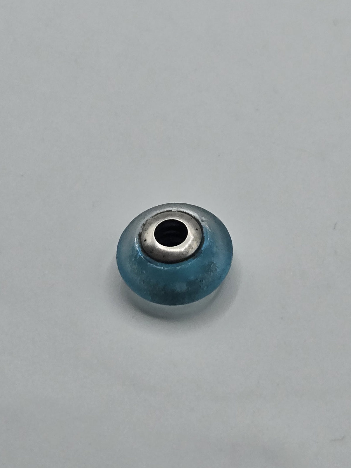 Pandora Frosted Turquoise Murano Glass Charm on a plain light background