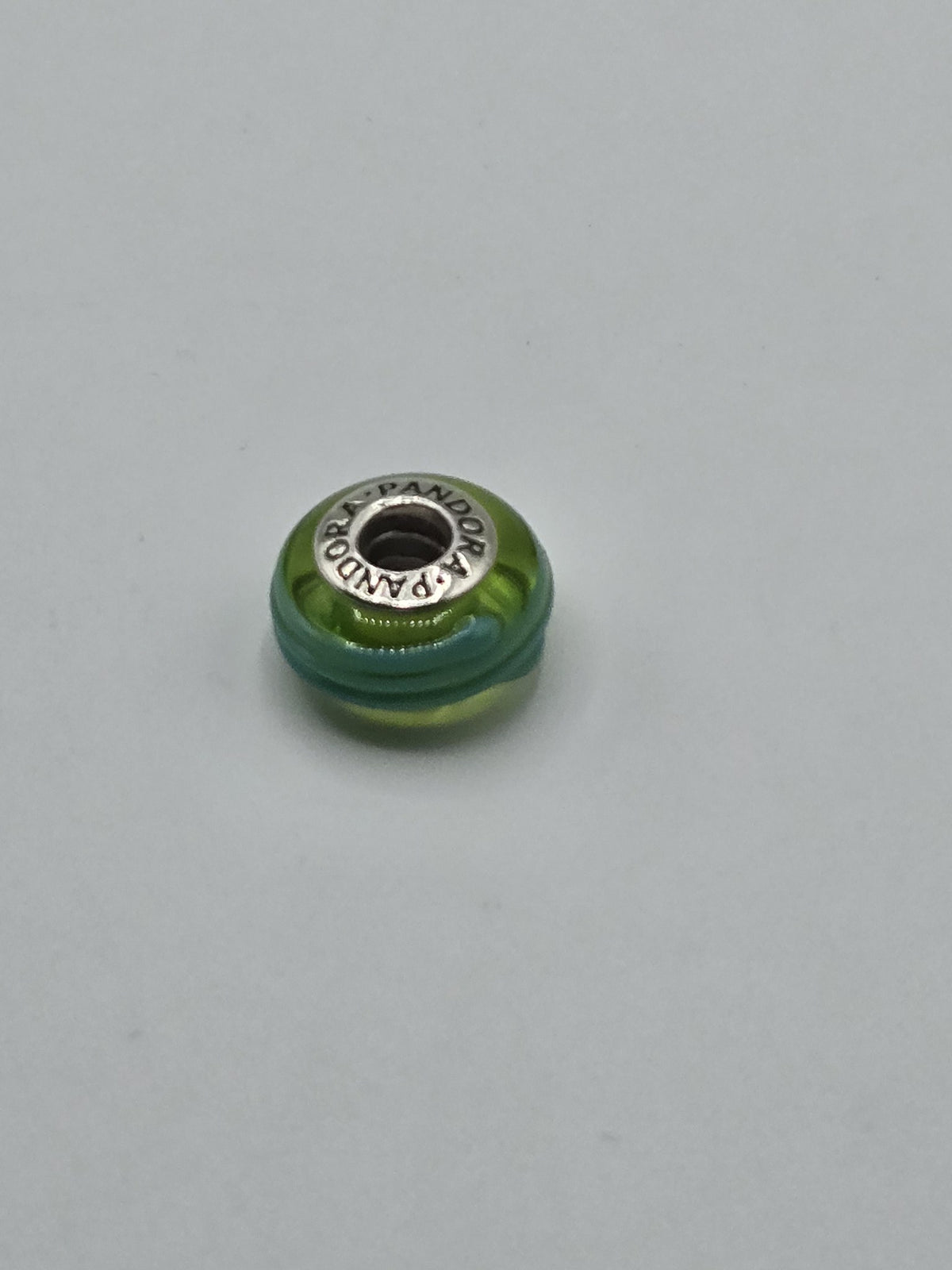 Pandora Green and Turquoise Ribbed Murano Glass Charm on a plain light background