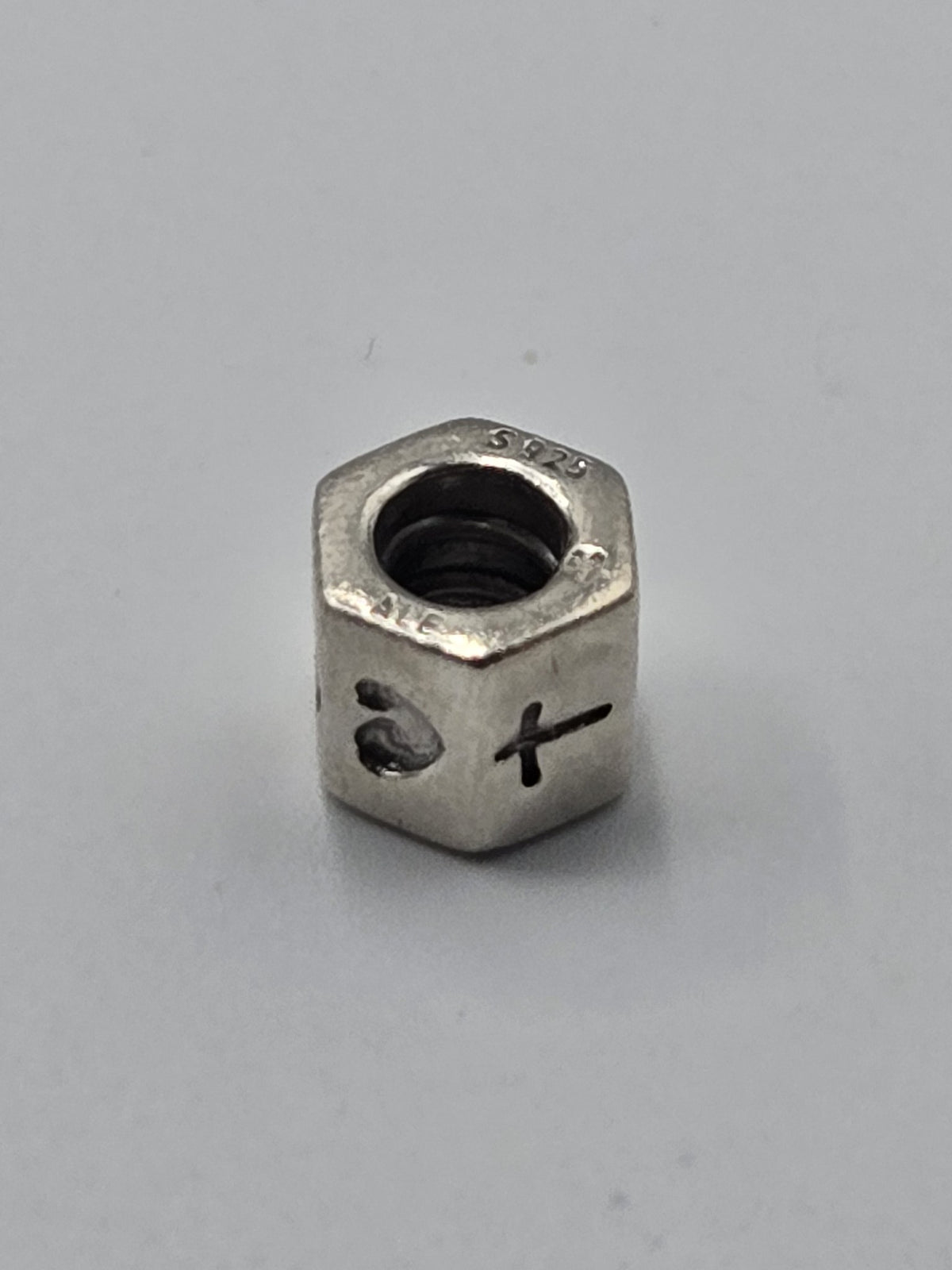 Pandora Heart and Cross Hexagon Charm on a plain light background