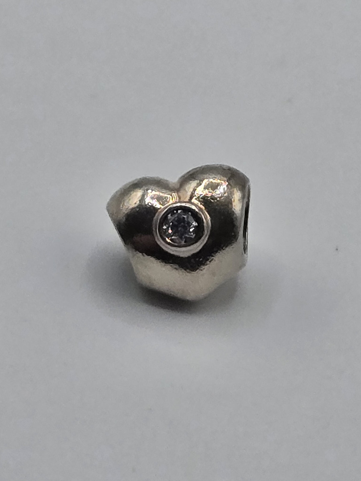 Pandora Heart Charm with Clear Stone on a plain light background