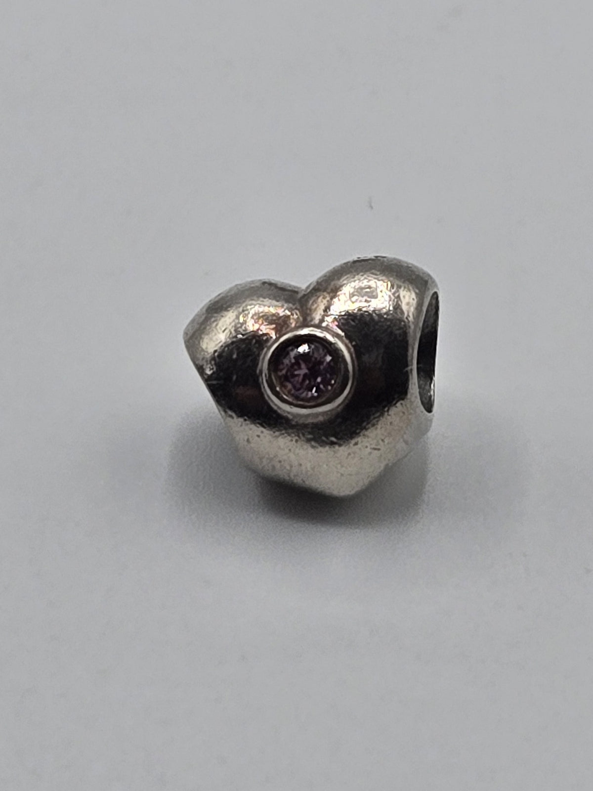 Pandora Heart Charm with Pink Stone on a plain light background