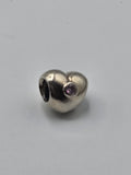 Pandora Heart Charm with Pink Stone on a plain light background
