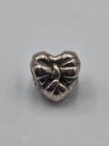 Pandora Heart with Bow Charm on a plain light background