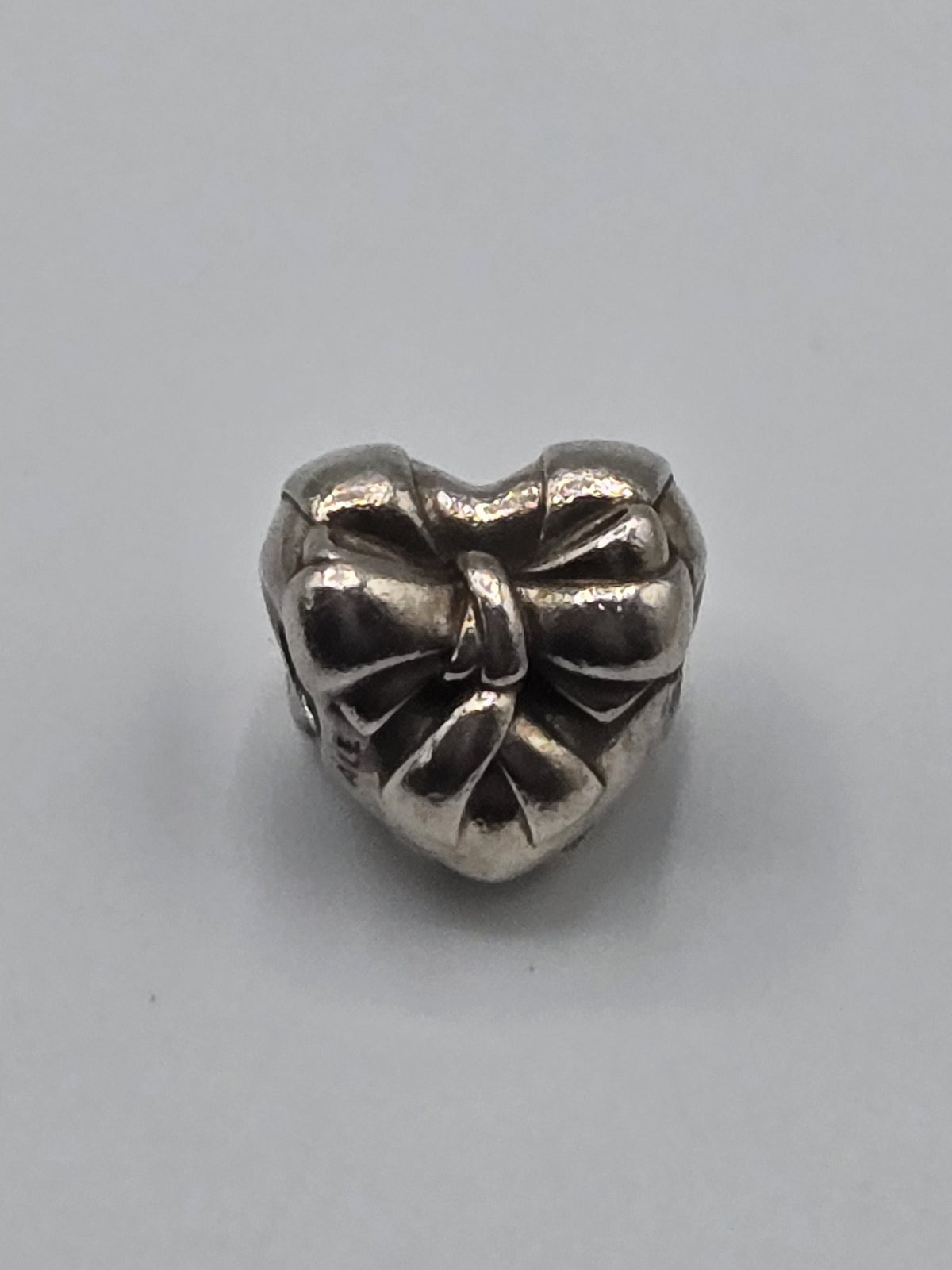 Pandora Heart with Bow Charm on a plain light background