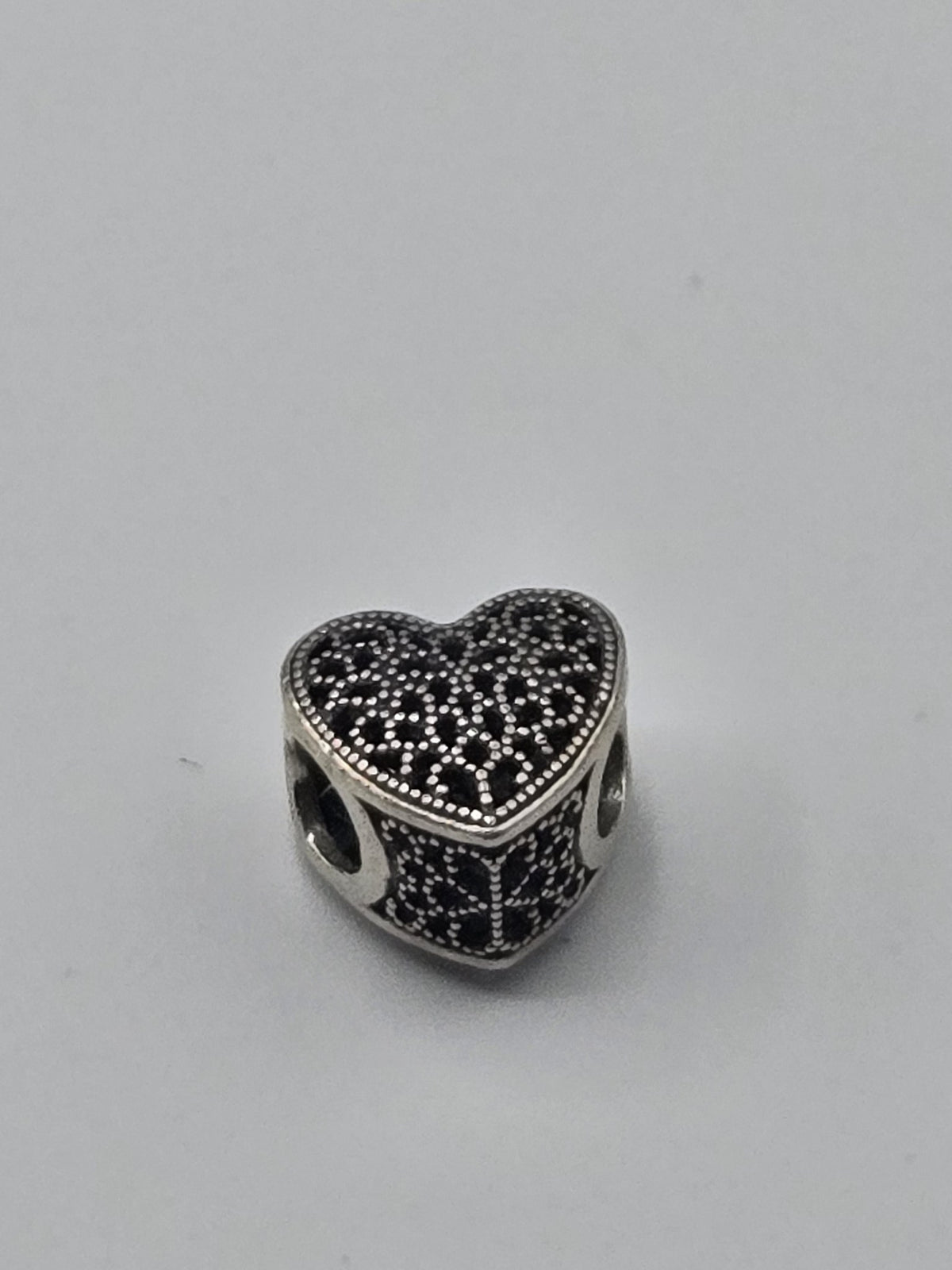 Pandora Lace Heart Charm on a plain light background