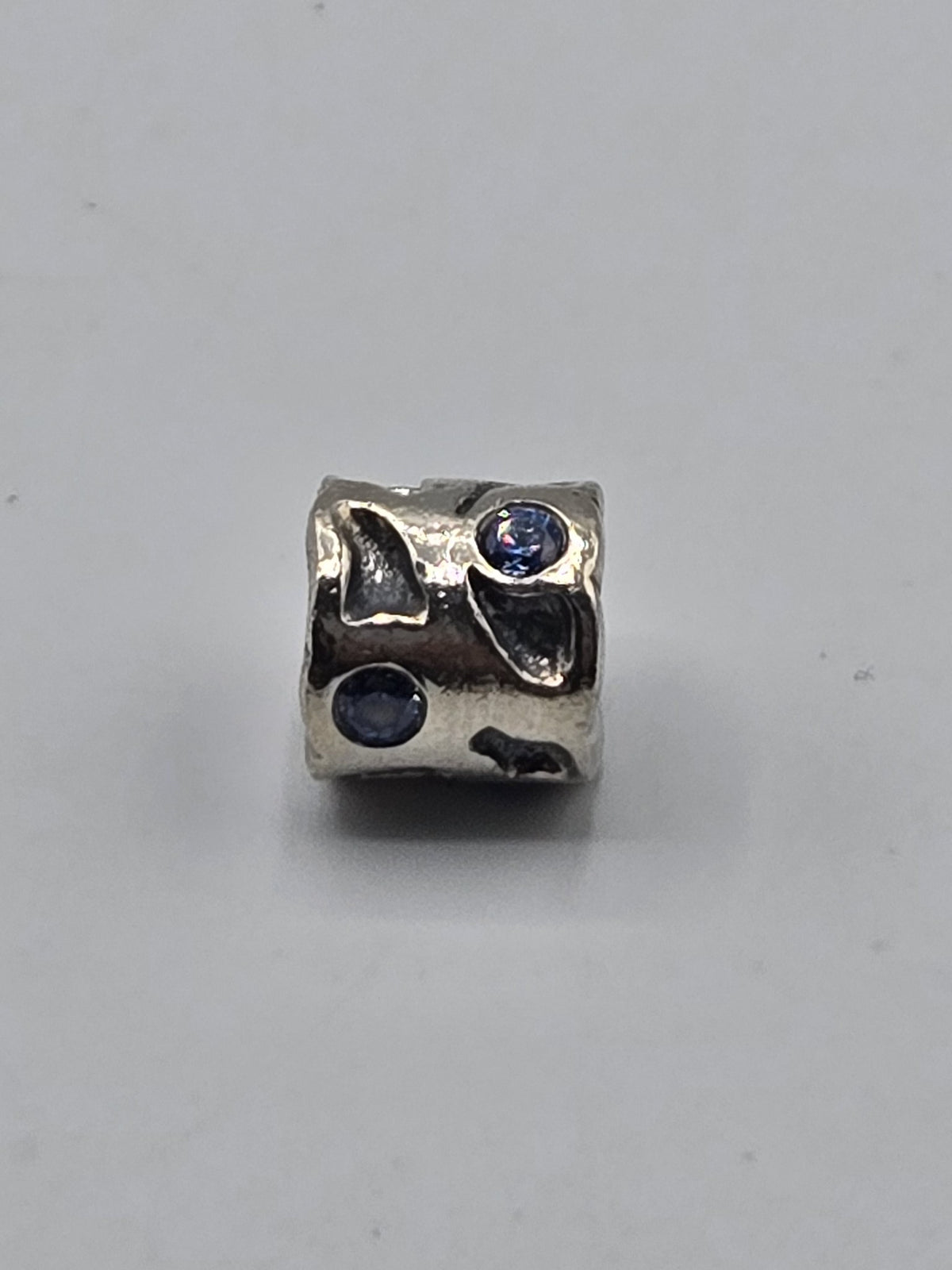 Pandora Leaf Charm with Blue Stones on a plain light background