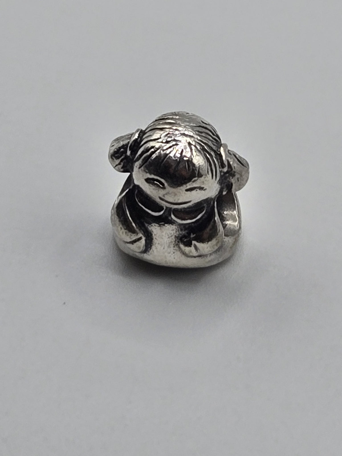 Pandora Little Girl with Bunches Charm on a plain light background