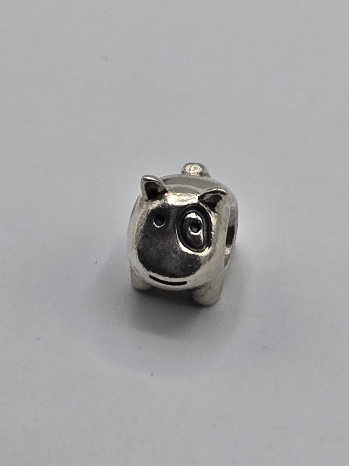 Pandora Little Pig Charm on a plain light background