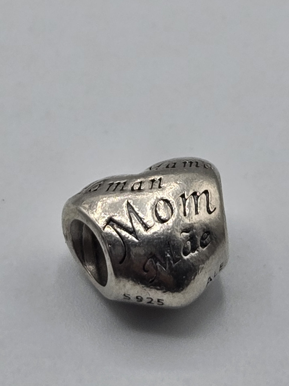 Pandora Mom in Many Languages Heart Charm on a plain light background