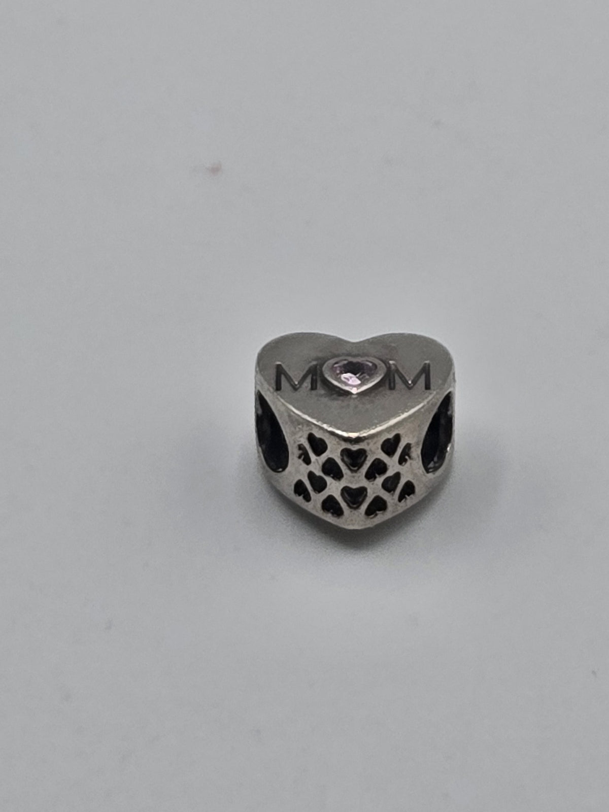 Pandora MOM Openwork Heart Charm on a plain light background