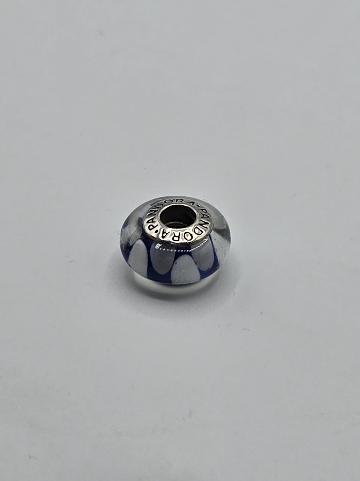 Pandora Navy and White Petal Murano Glass Charm on a plain light background