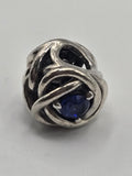 Pandora Openwork Knot Charm with Blue Stone on a plain light background