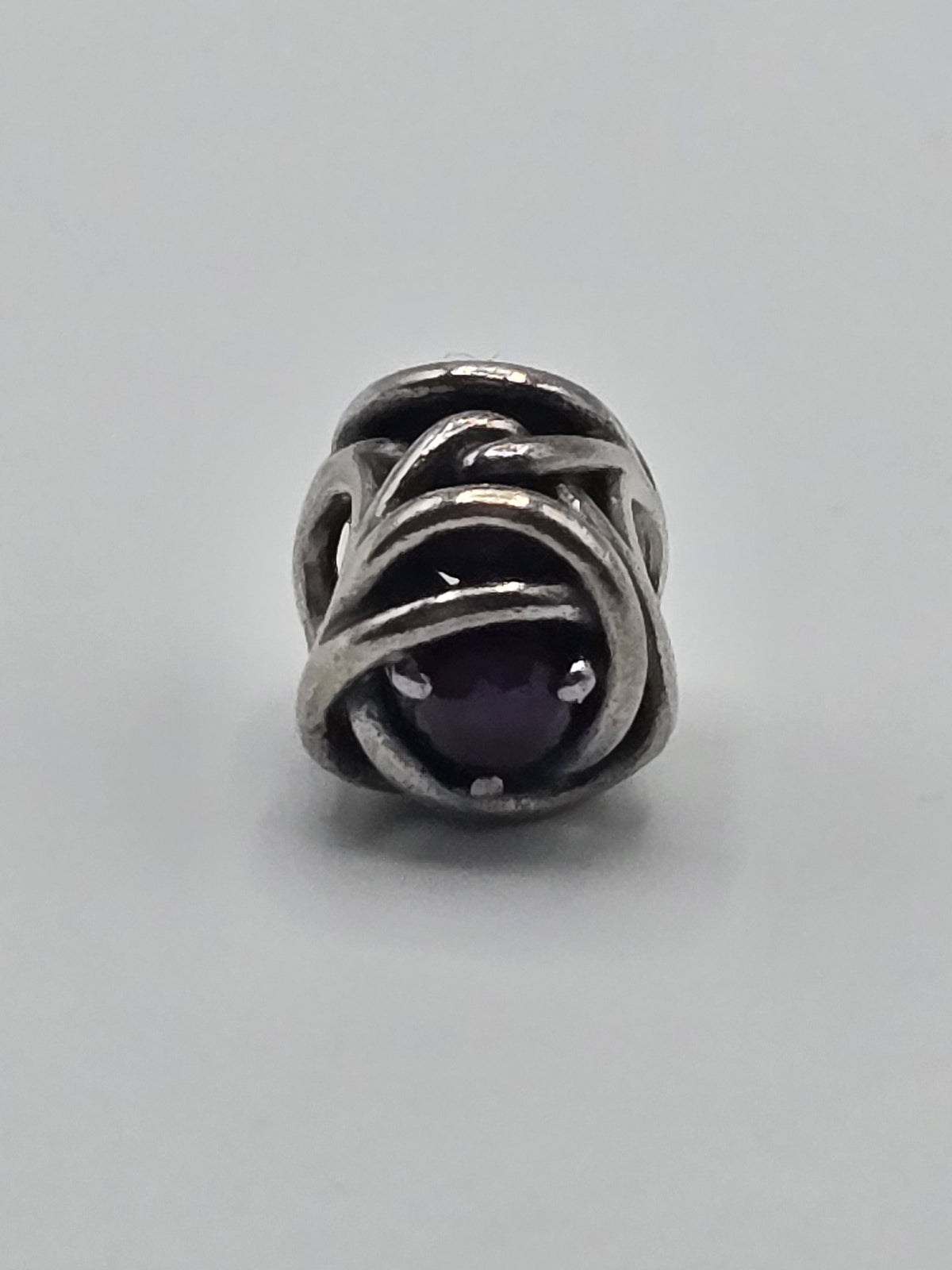 Pandora Openwork Knot Charm with Purple Stone on a plain light background