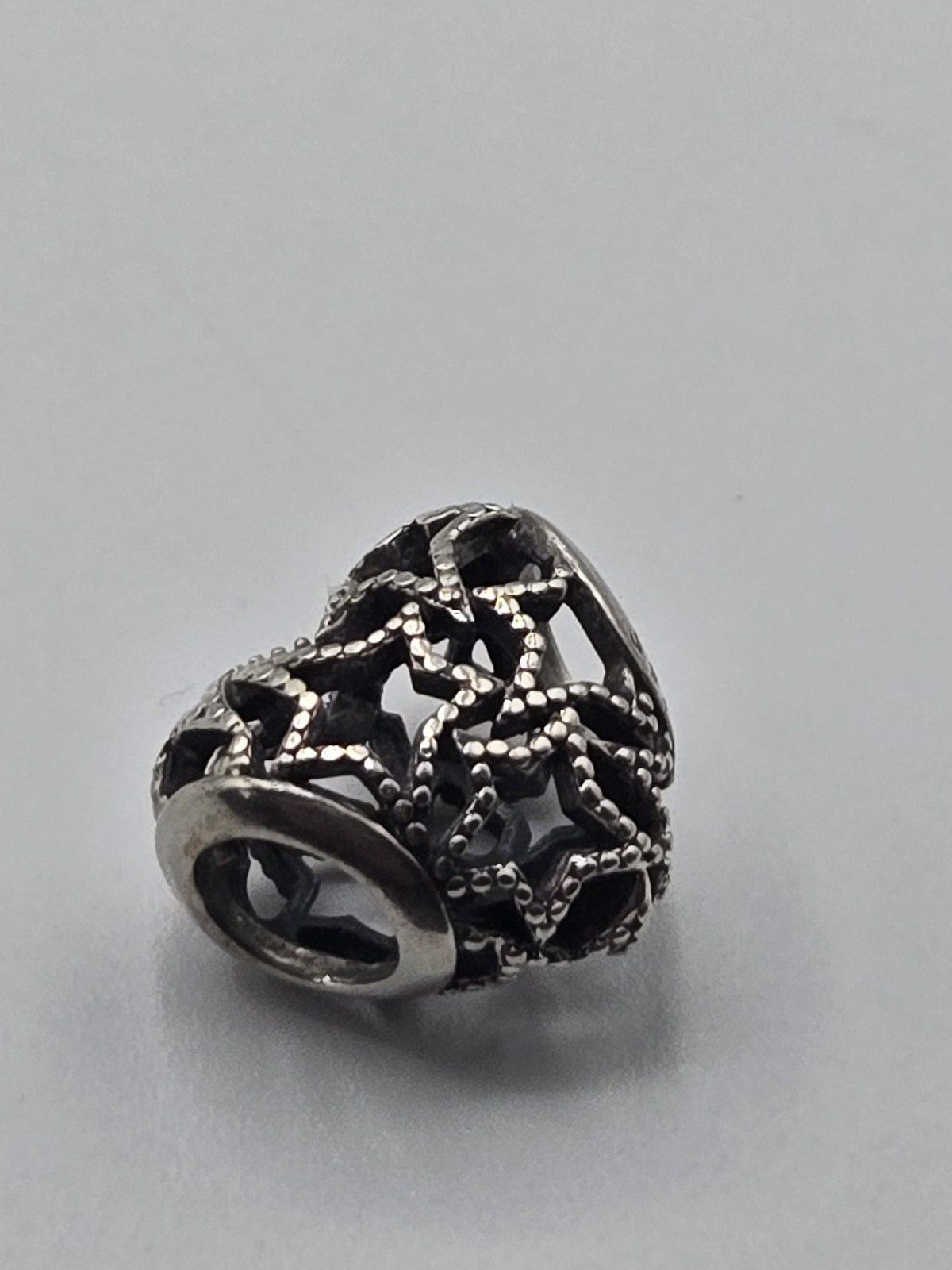 Pandora Openwork Stars Charm on a plain light background