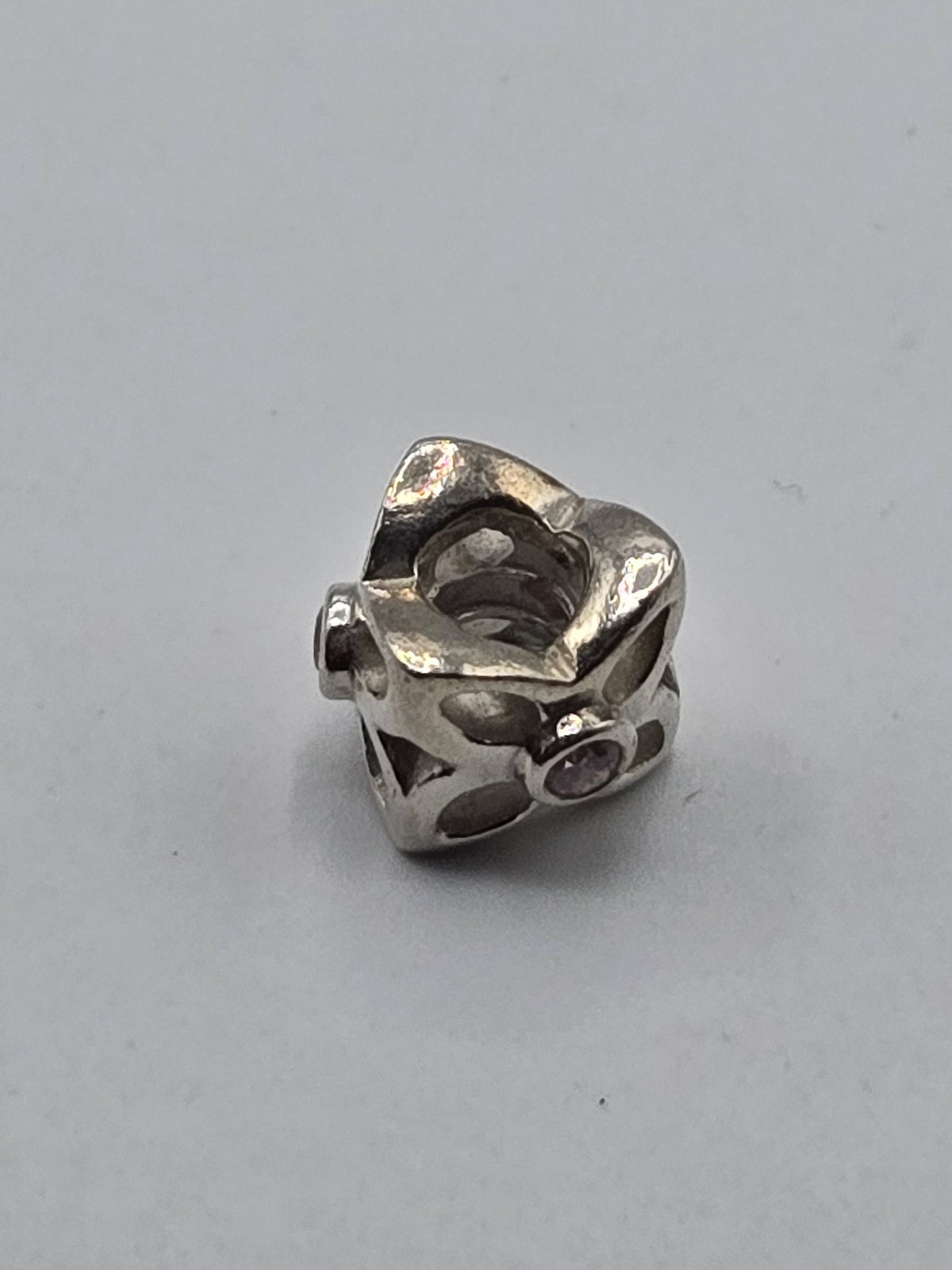Pandora Openwork Twist Charm with Pink Stones on a plain light background