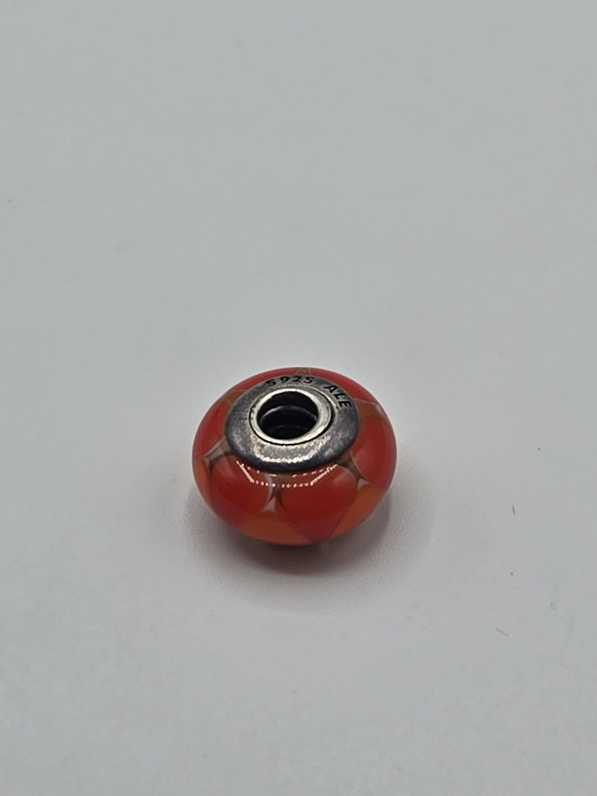 Pandora Orange-Red Heart Murano Glass Charm on a plain light background