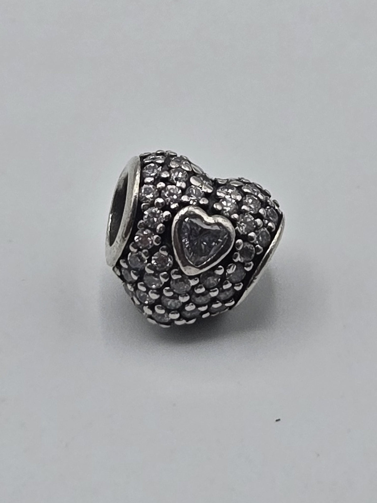 Pandora Pavé Heart Charm with Clear Heart Stone on a plain light background