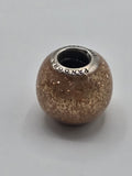 Pandora Peach Glitter Murano Glass Charm on a plain light background