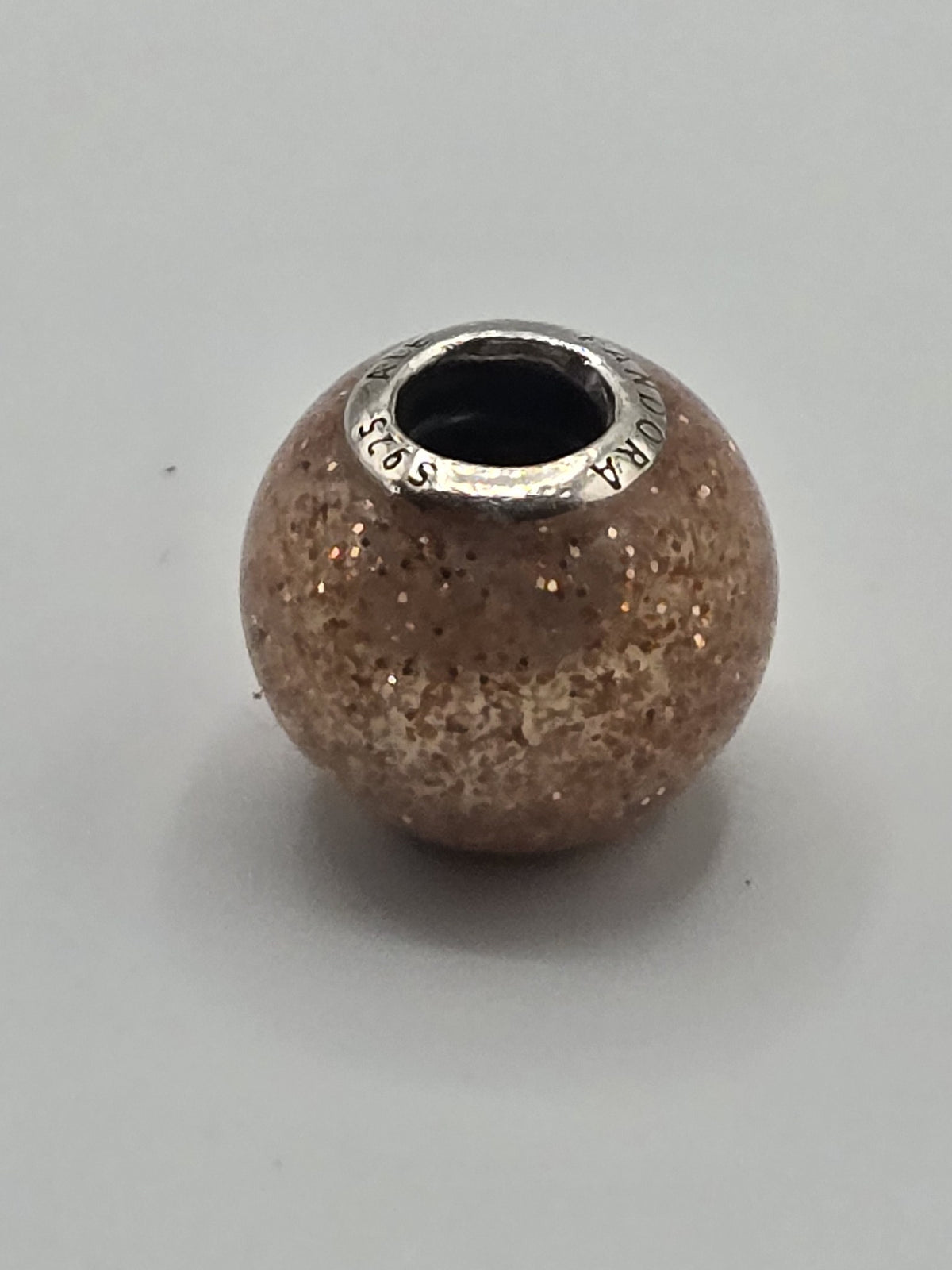 Pandora Peach Glitter Murano Glass Charm on a plain light background