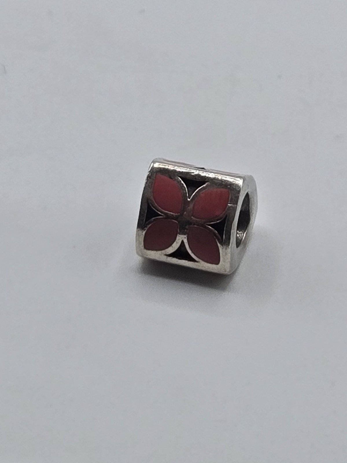 Pandora Pink Enamel Petal Triangle Charm on a plain light background