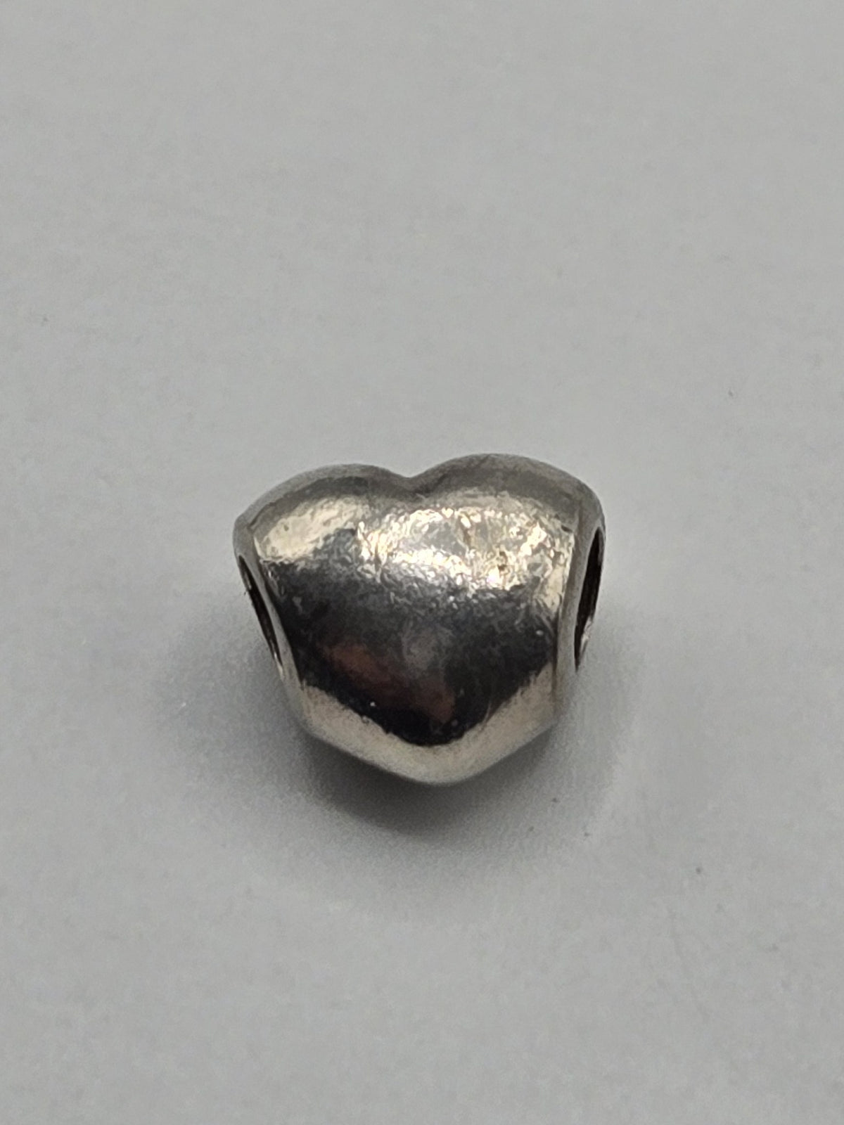 Pandora Polished Heart Charm on a plain light background