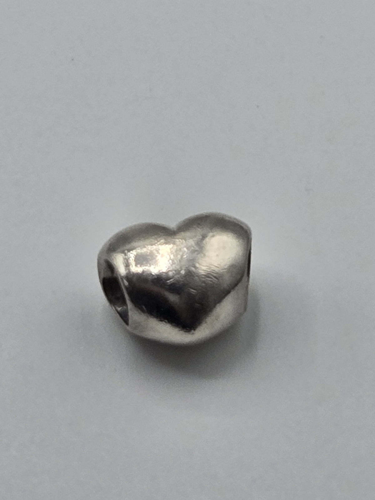 Pandora Polished Heart Charm on a plain light background