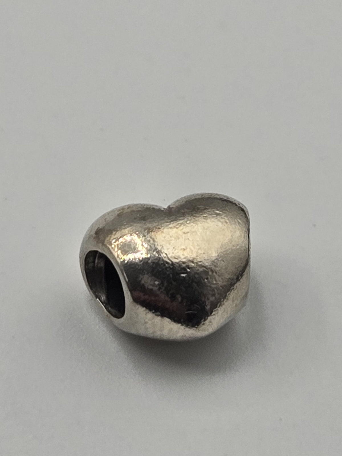 Pandora Polished Heart Charm on a plain light background