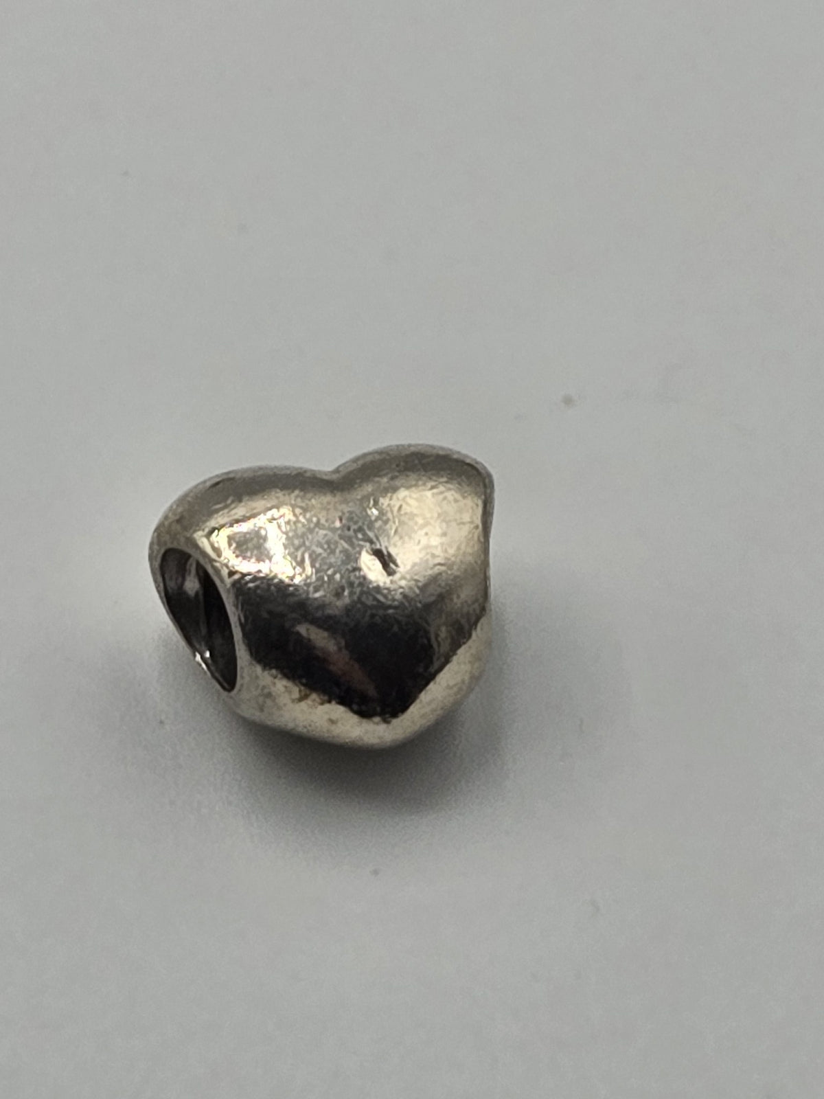 Pandora Polished Heart Charm on a plain light background