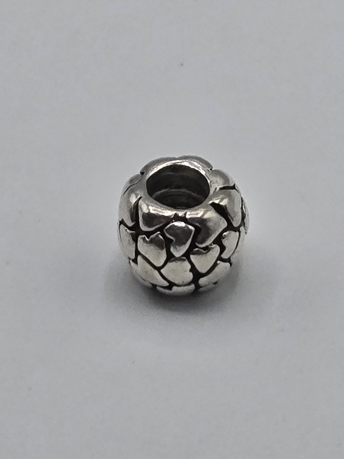 Pandora Raised Hearts Charm on a plain light background