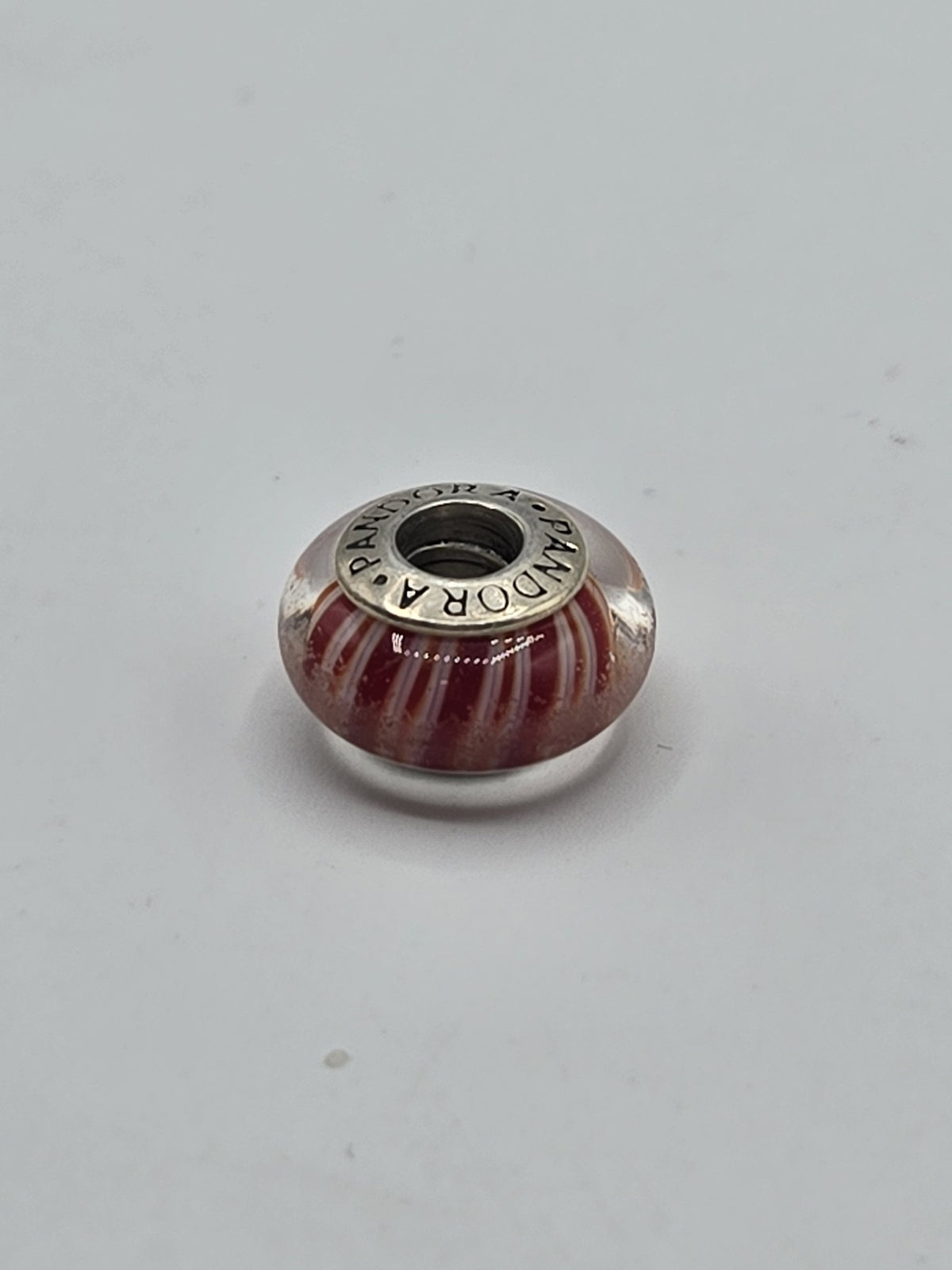 Pandora Red and White Candy Stripe Murano Glass Charm on a plain light background