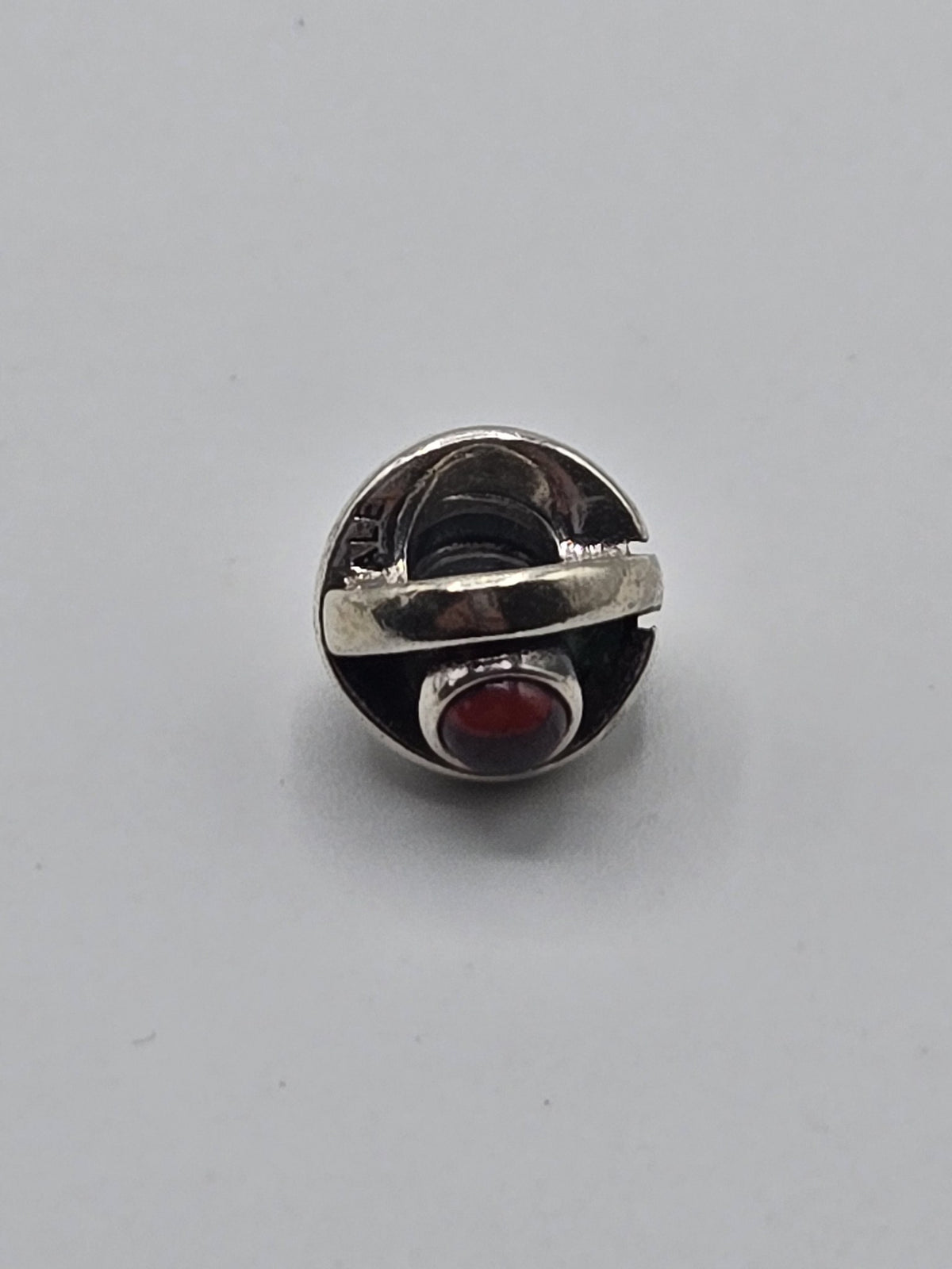 Pandora Silver Band Charm with Red Stone on a plain light background