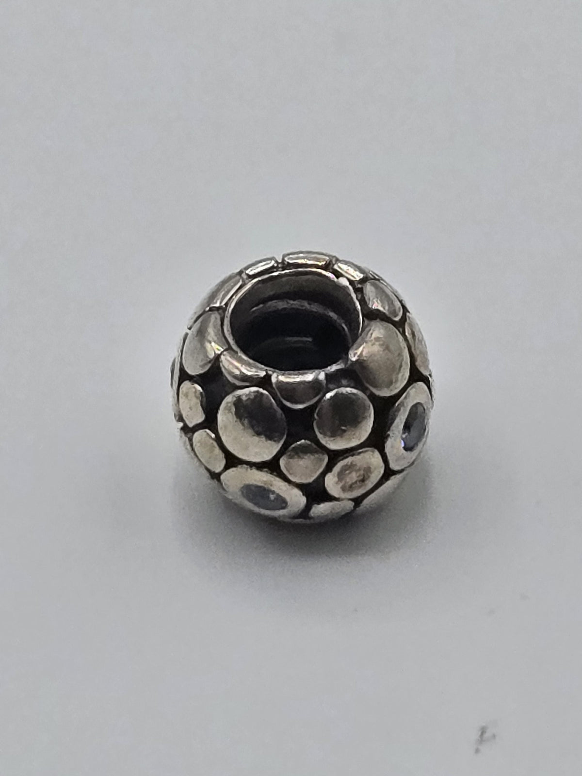 Pandora Silver Pebbles Charm with Pale Blue Stones on a plain light background