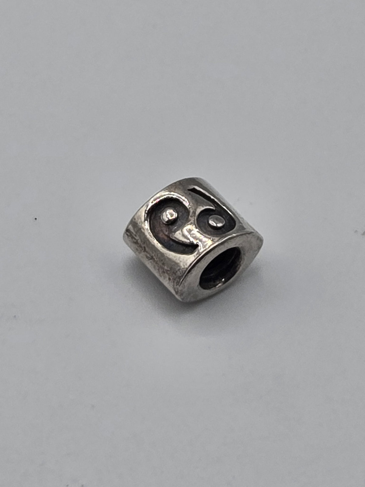 Pandora Silver Swirl Triangle Charm on a plain light background