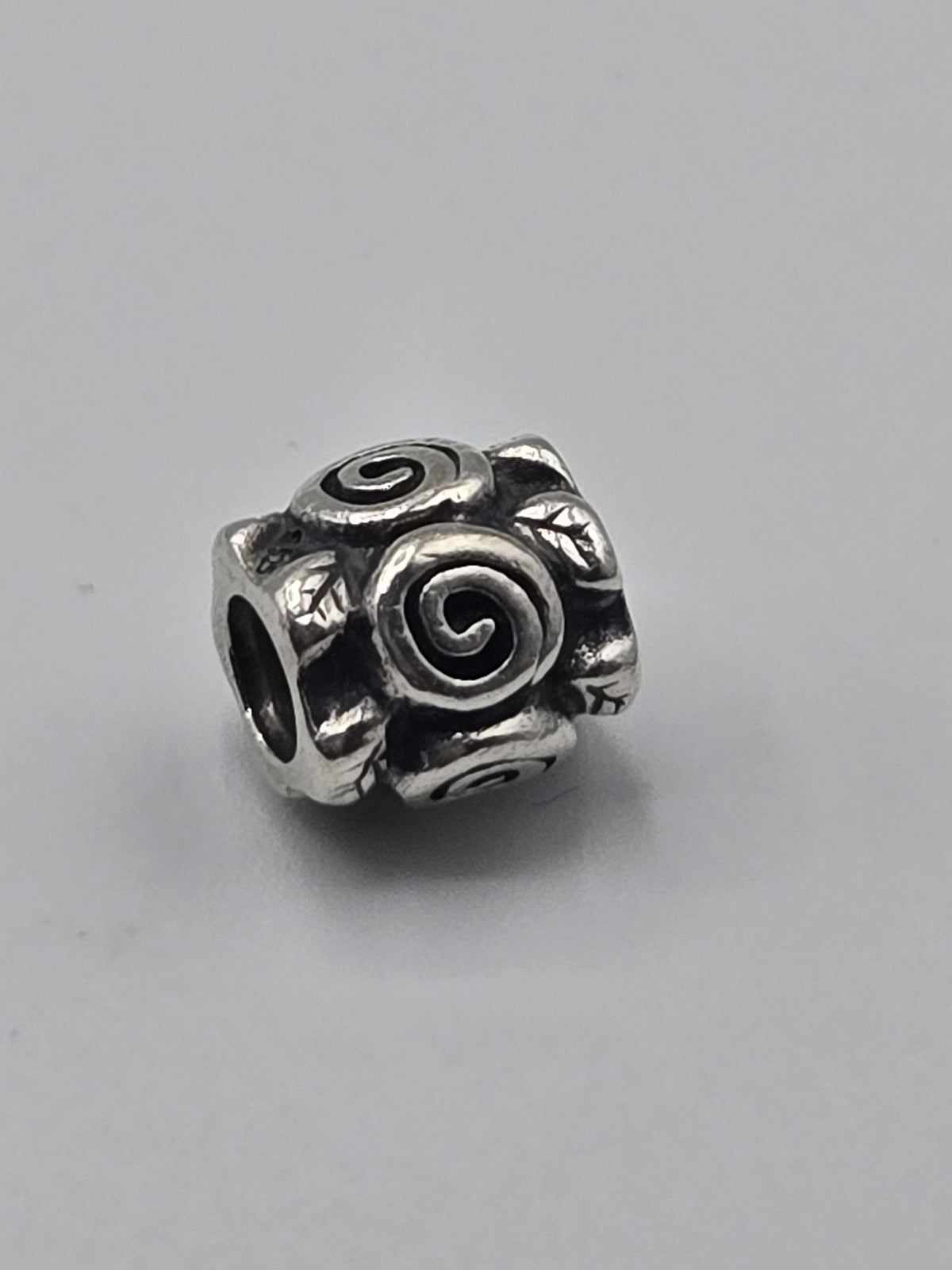 Pandora Spiral Roses Charm on a plain light background