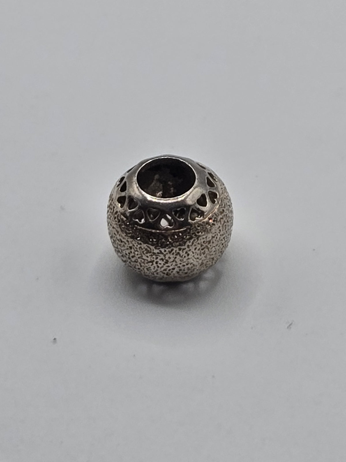 Pandora Stardust Openwork Hearts Charm on a plain light background