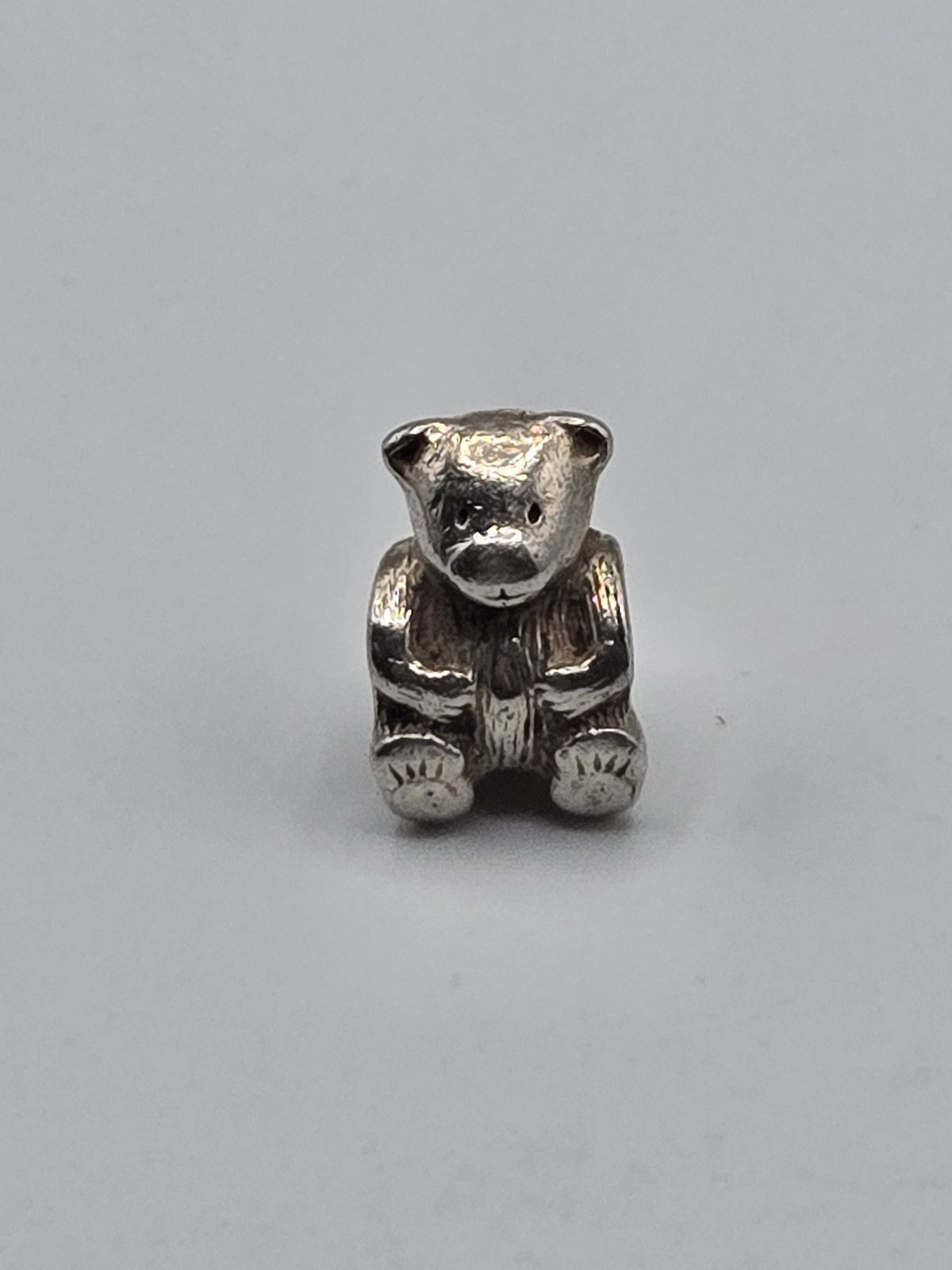 Pandora Teddy Bear Charm on a plain light background