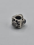 Pandora Triangle Charm with Grey Stones on a plain light background