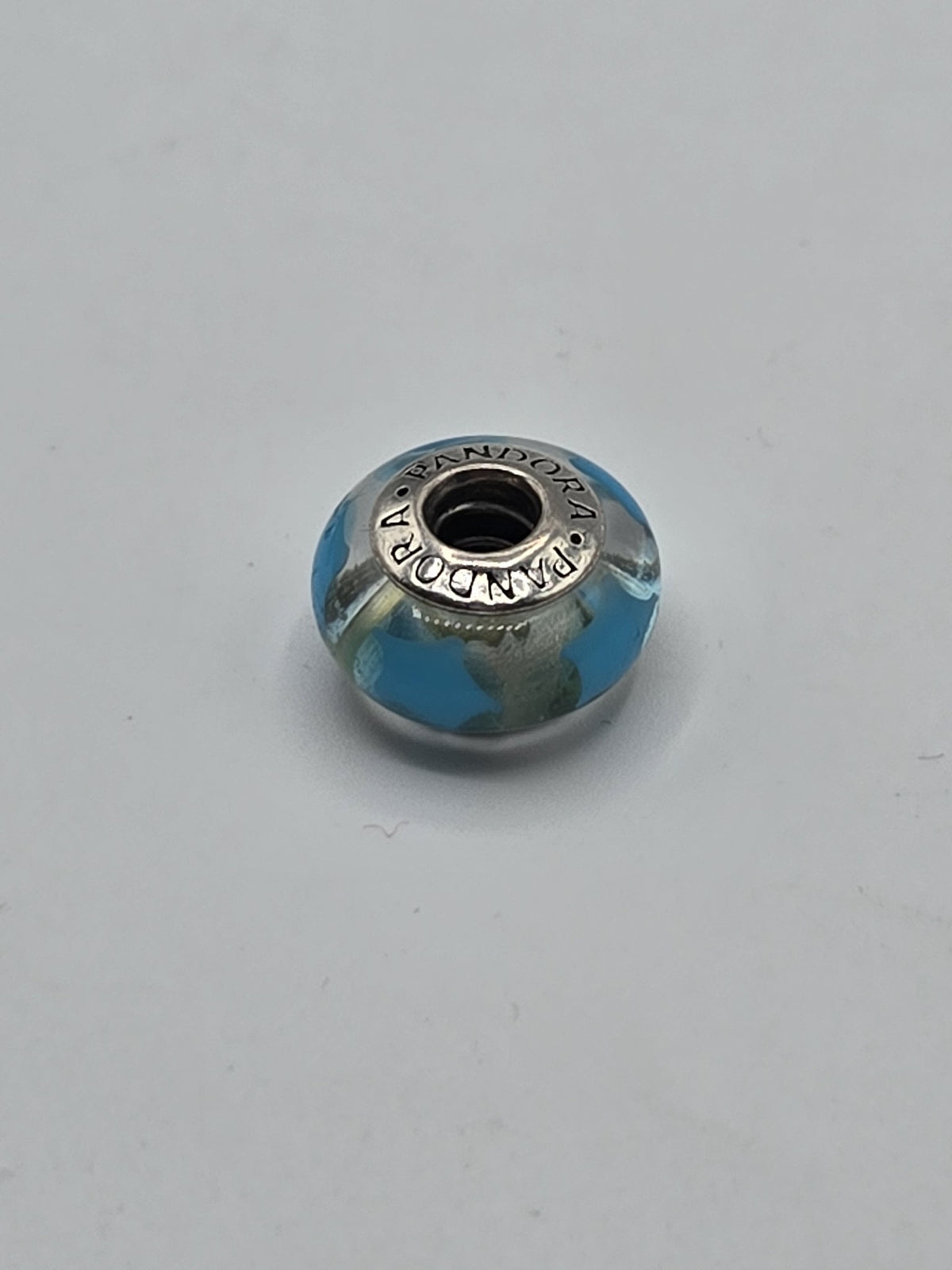 Pandora Turquoise and Silver Swirl Murano Glass Charm on a plain light background