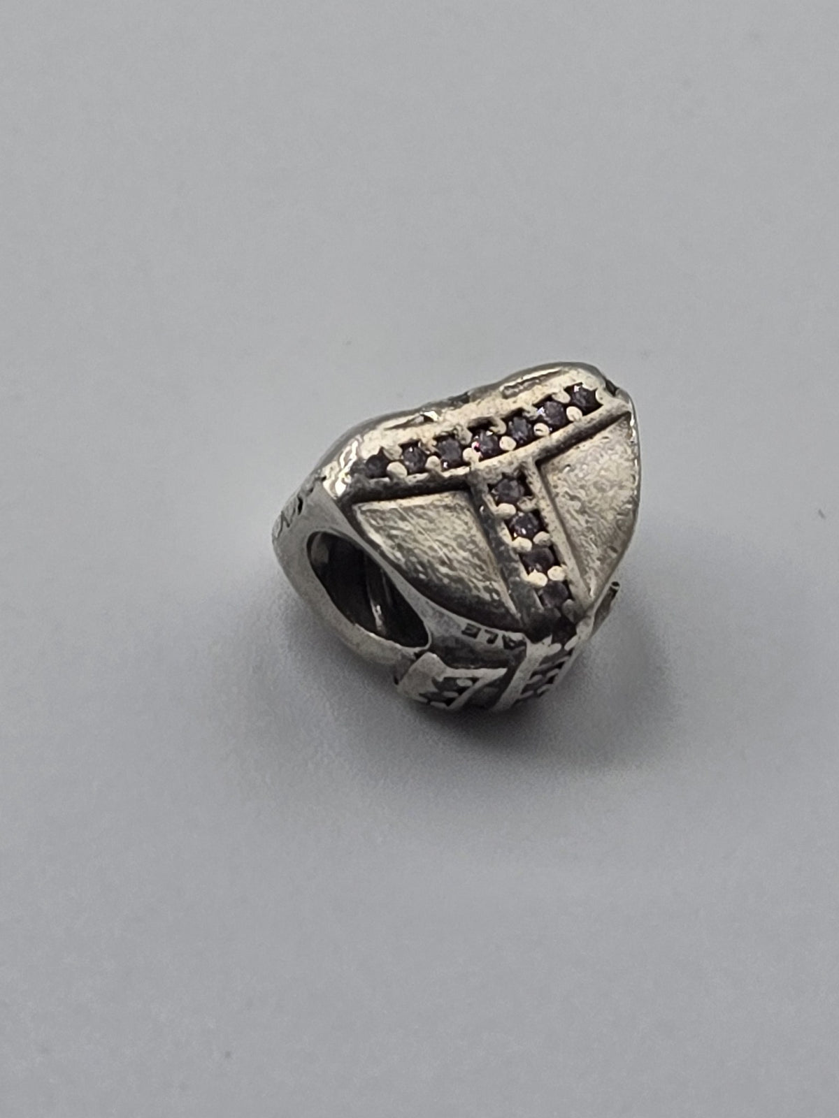 Pandora Wrapped Heart Charm with Purple Stones on a plain light background